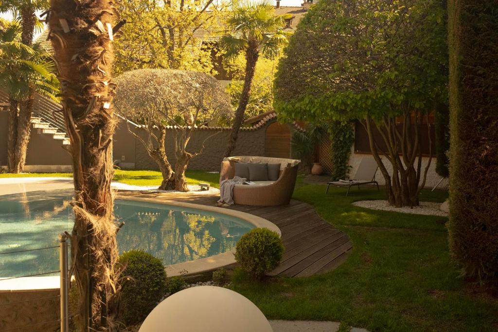 拉古多穆尔巴赫霍夫酒店的后院设有游泳池、椅子和树