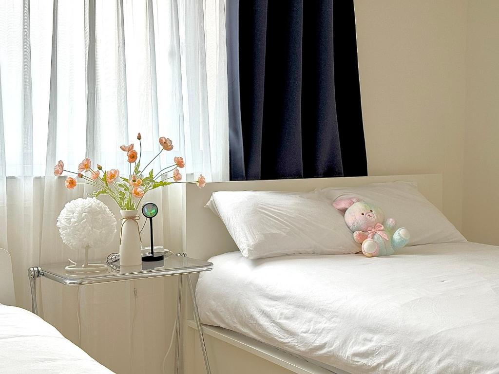 首尔사당 그린나래 스테이的一张白色的床,枕头上放着一只动物
