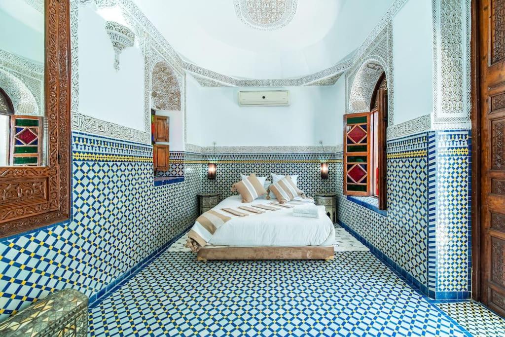 马拉喀什Riad Khadoj-Marrakech-Traditional的卧室拥有蓝色和白色的瓷砖墙壁,配有1张床