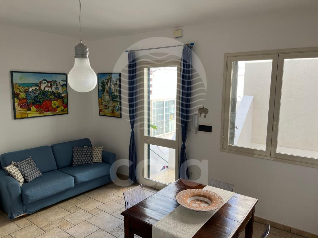 切萨雷奥港Il Timone的客厅配有蓝色的沙发和桌子