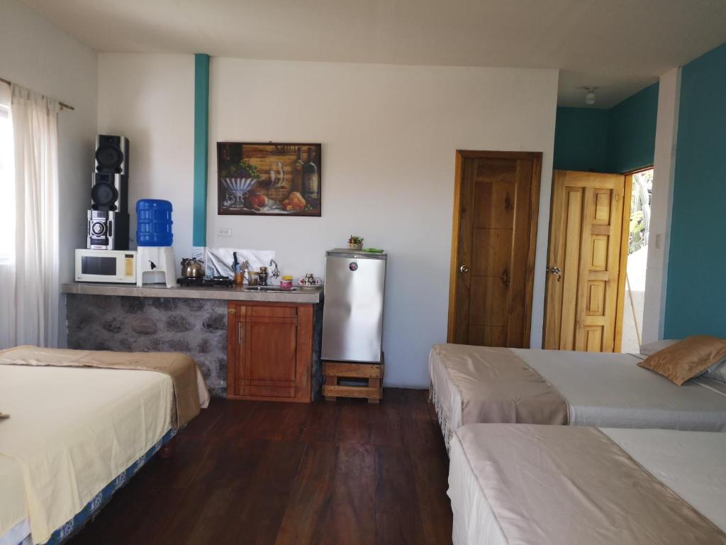 巴克里索莫雷诺港Hostal Cabañas Don Jorge的客房设有两张床和一台冰箱。