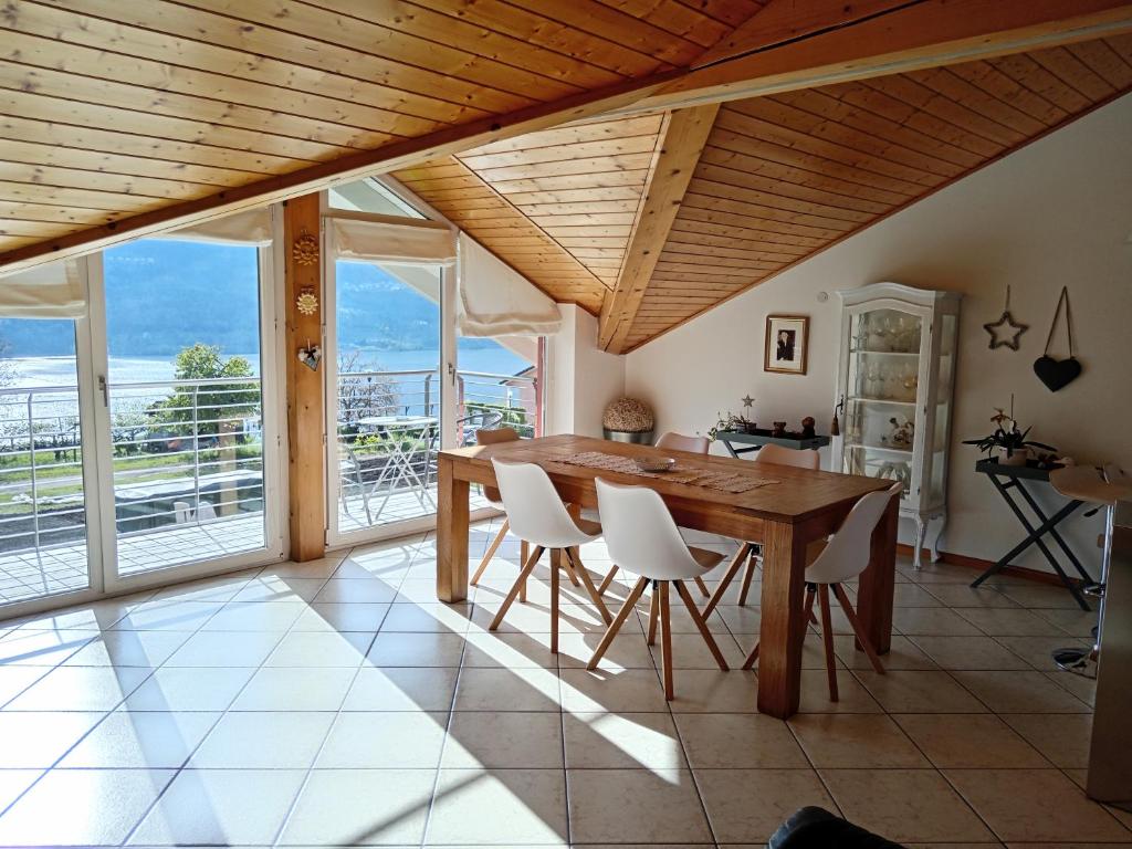 Tenna La Posada sul Colle的一间带木桌和白色椅子的用餐室
