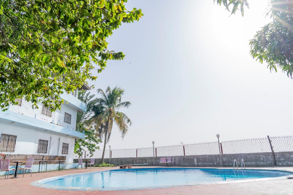 科纳克里Hotel Azur Conakry的大楼前的游泳池