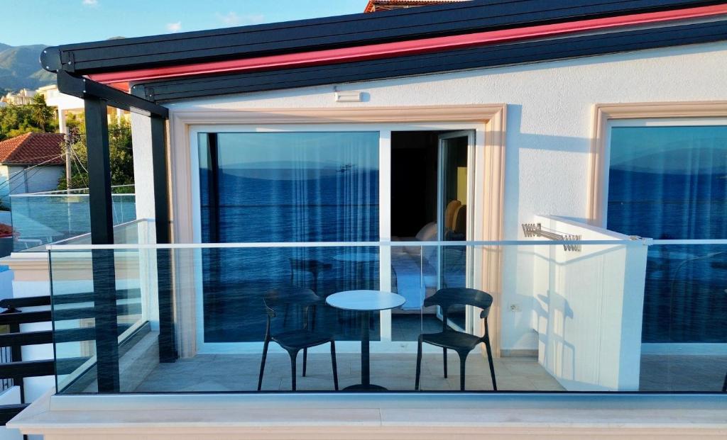 希马拉Ionian Terrace的一个带桌子和两把椅子的玻璃阳台