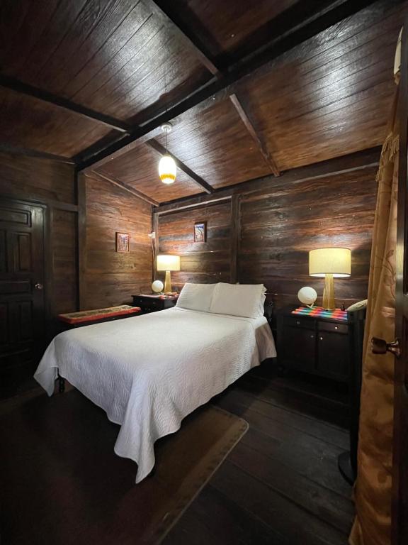 安赫莱斯镇Cabaña entre orquídeas的卧室配有木墙内的一张床