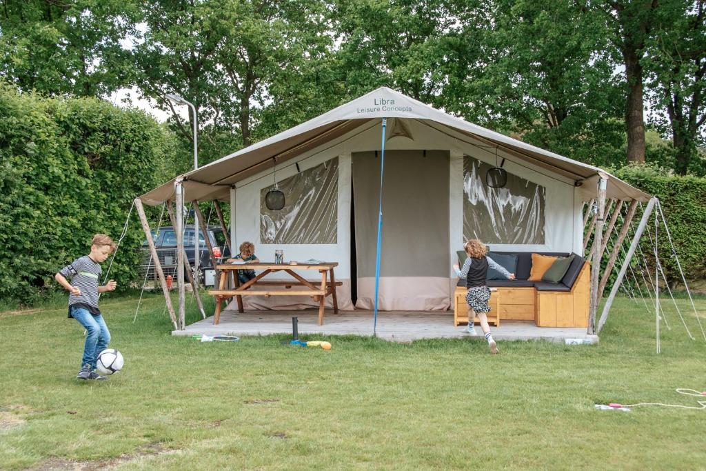 霍尔滕Luxe kamperen bij Procamp4all的两个孩子在帐篷里玩足球