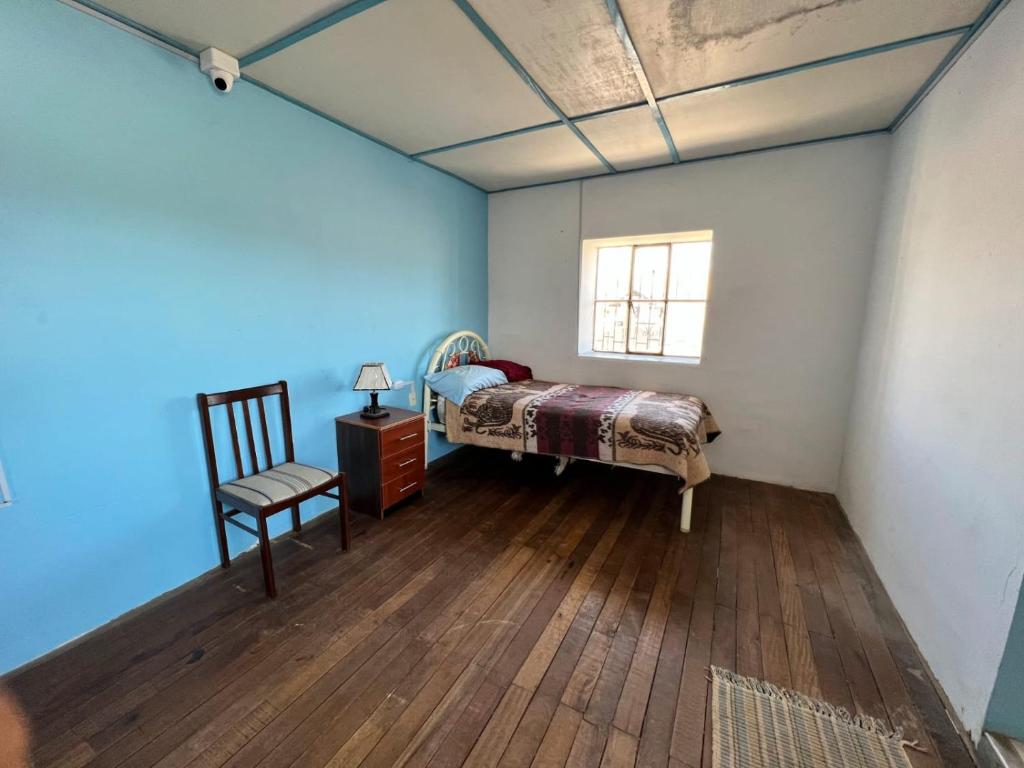 豪哈Casa Rosita Sausa的卧室配有床、椅子和窗户。