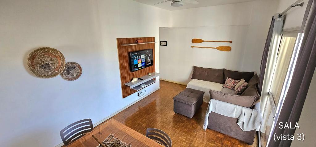 瓜拉派瑞Centro Guarapari - espaço & conforto - WI-FI的带沙发和电视的客厅
