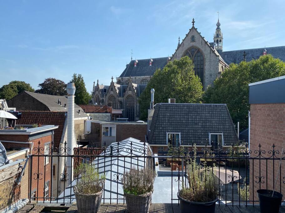 豪达Apartment City Center Terrace with Iconic View的教堂前种有盆栽植物的阳台