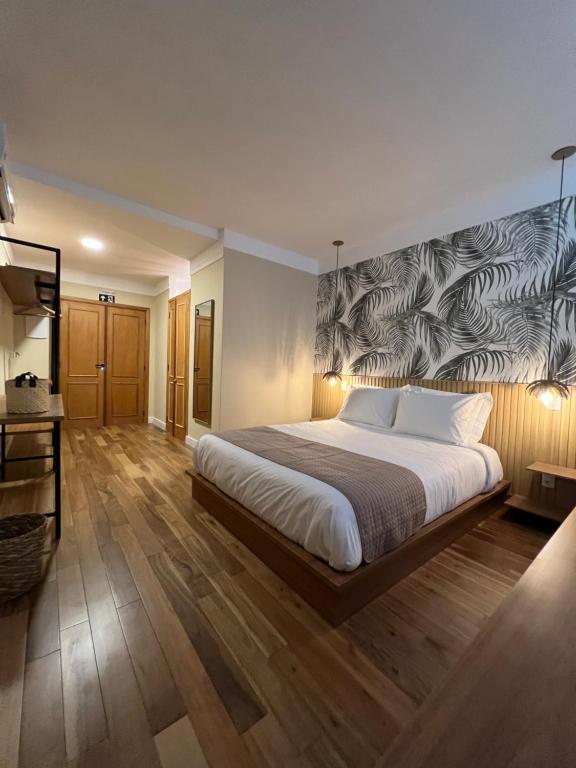 蒙特韦尔迪JaguatiricaCoffee Hospitality的卧室配有一张大床,墙上挂有壁画