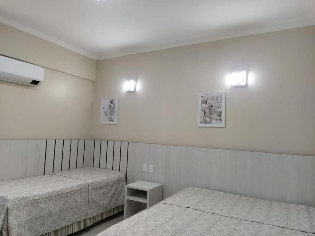 卡达斯诺瓦斯Spazzio diRoma的一间卧室配有两张床,墙上有两盏灯