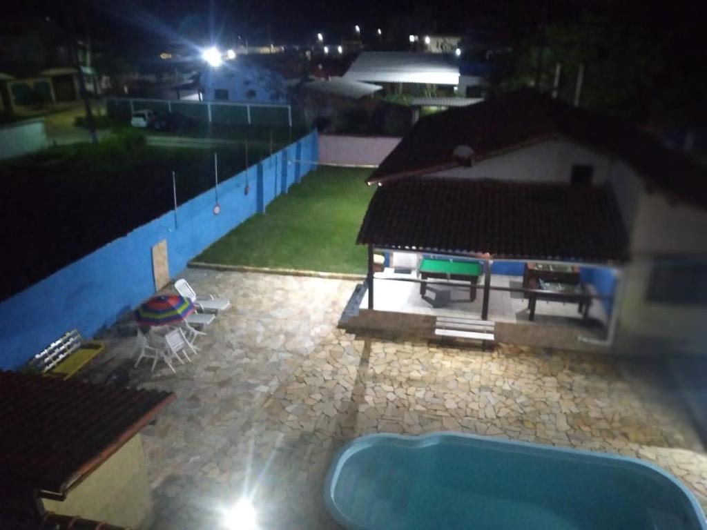 萨夸雷马Excelente casa em Saquarema a 100 passos do mar的享有大楼的景色,在晚上设有游泳池