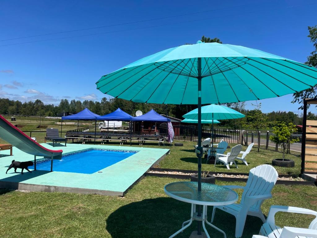 San José de la MariquinaEl pantano de sherk y fiona的一个带桌子和蓝伞的游泳池