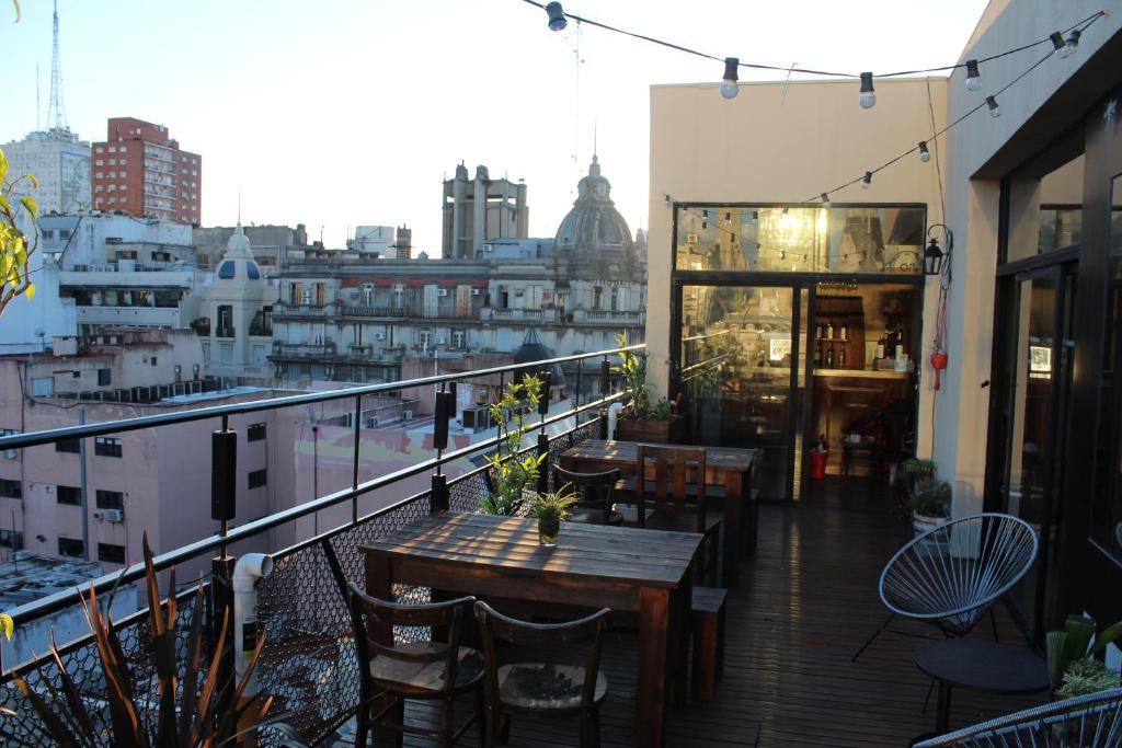 布宜诺斯艾利斯Parla Hostel的设有带桌椅的市景阳台。