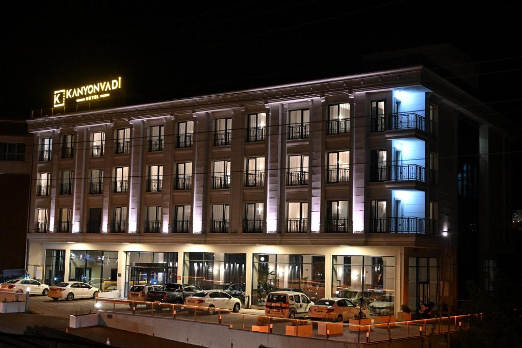 BostanbüküKANYON VADİ HOTEL的一座建筑,晚上有汽车停在外面