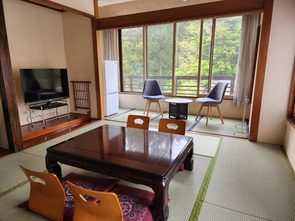 日光大和屋ホテルいろは的客厅配有桌椅和电视。
