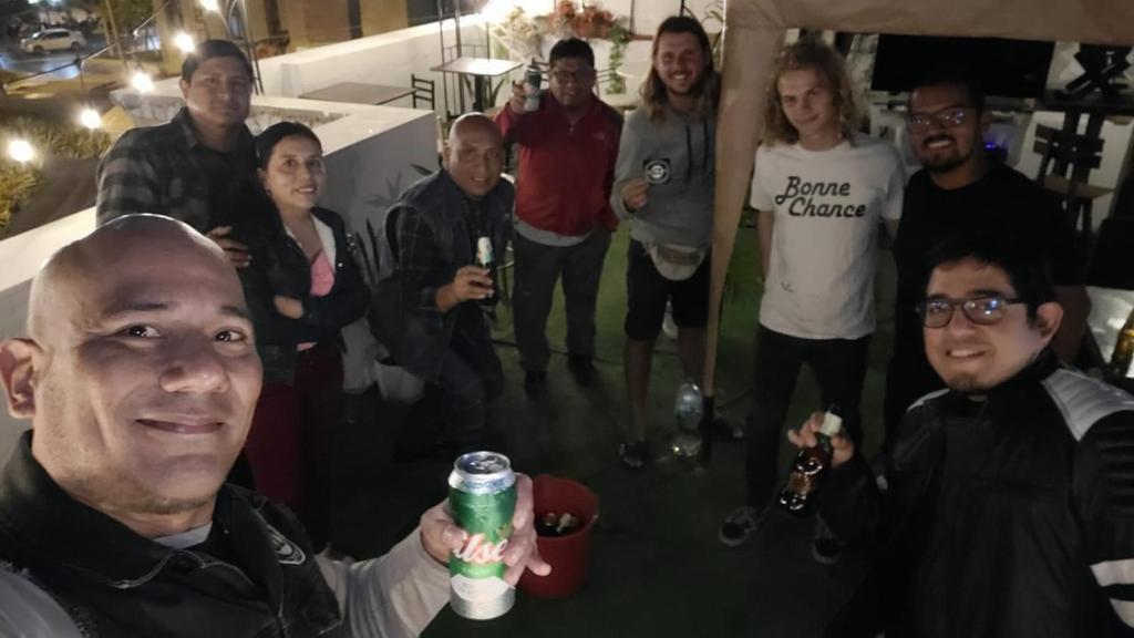 利马Quinoa Backpackers Hostel的一群人站在一个喝着饮料的人身边
