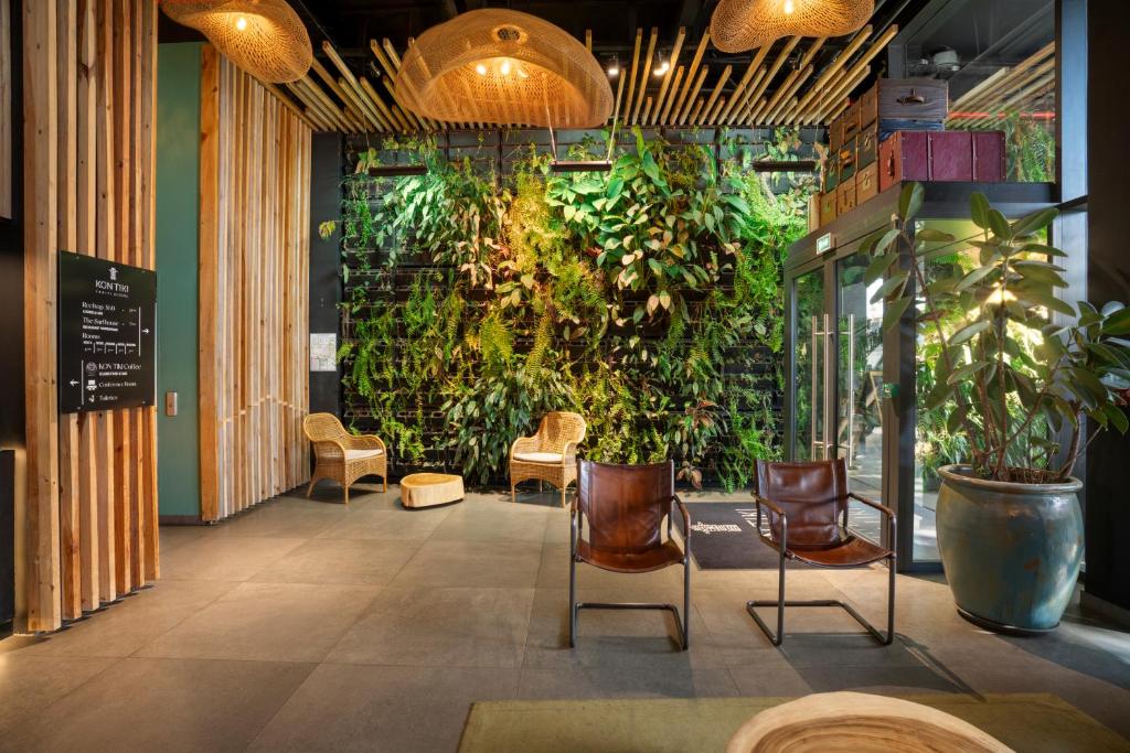 帕皮提Boutique Hôtel Kon Tiki Tahiti的一间设有绿色墙壁、椅子和植物的房间