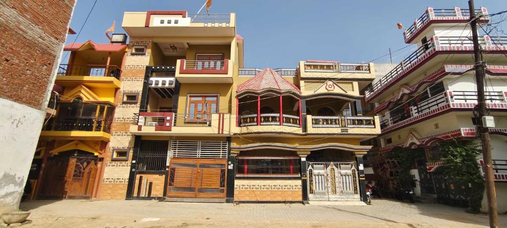 AyodhyaOYO Home Anandi Homestay的一座高大的建筑,旁边设有阳台