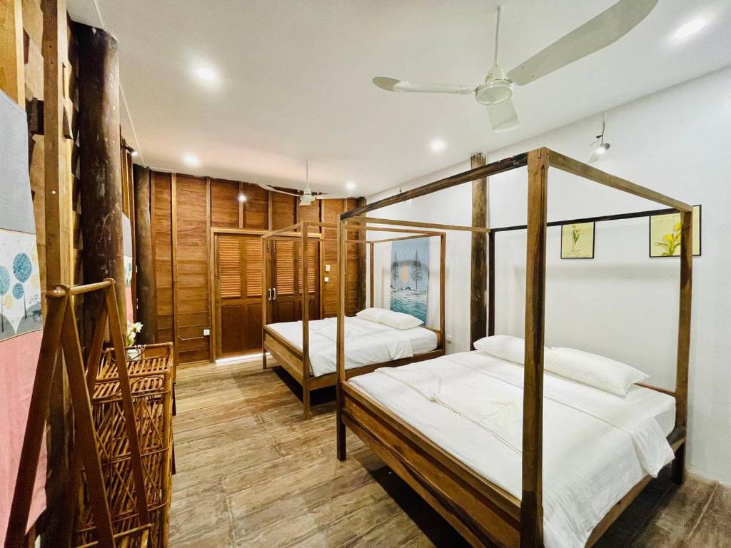 贡布HOLY VILLA 4rooms, 5beds, 6baths, 1KCH, 1LR riverside private villa的一间卧室设有两张床和天花板