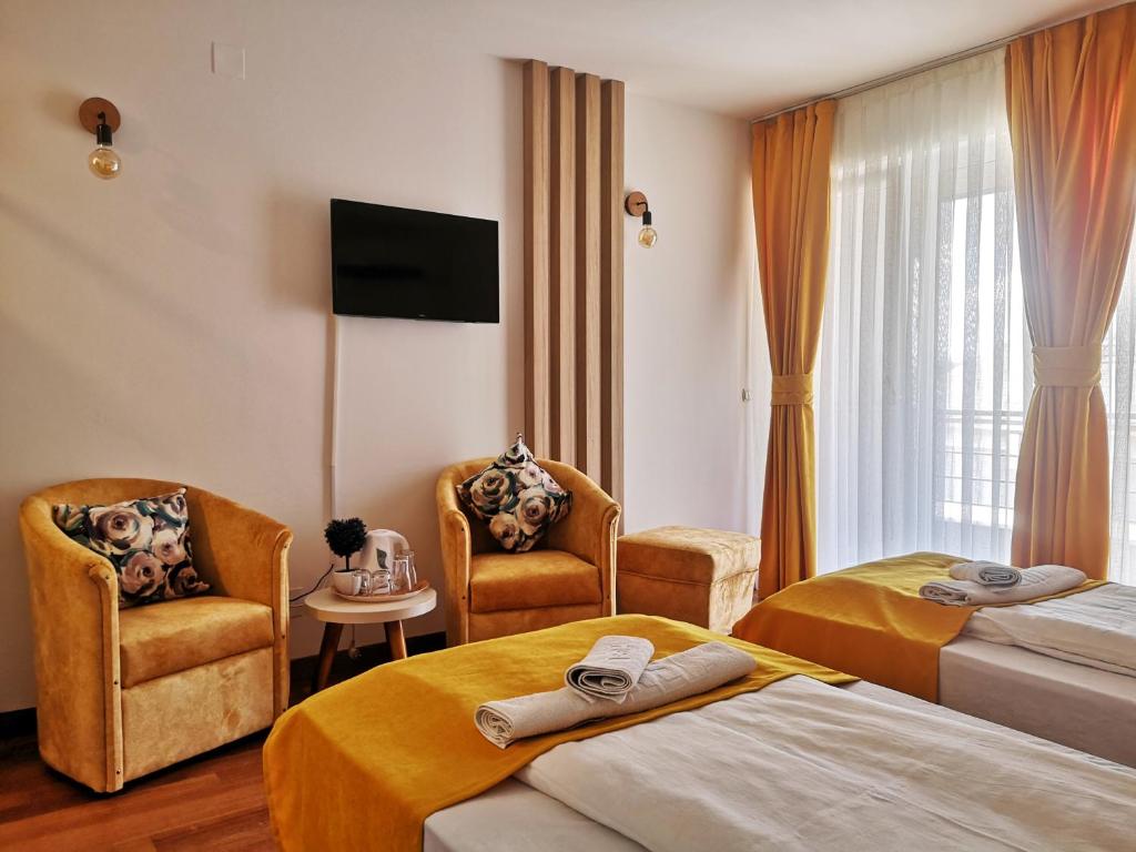 佩斯塔尼Villa Pestani的酒店客房,配有两张床和两把椅子