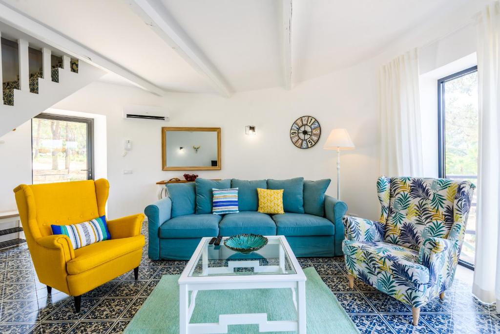 韦尔都勒博Casa dos Sonhos的客厅配有蓝色的沙发和两把椅子