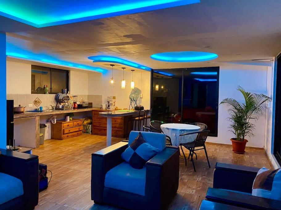 基多Villa Mirlo – Escondite de Lujo en Quito的带沙发的客厅和带蓝光的厨房