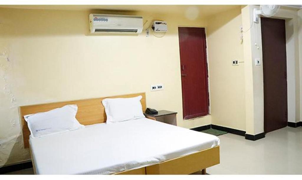 马杜赖FabExpress Sivabhagya Annex的一间医院房间,里面设有一张床和墙上的加热器