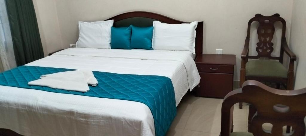 科钦Elim Homestay Fort Kochi的一间卧室配有一张大床,提供蓝白色的毯子