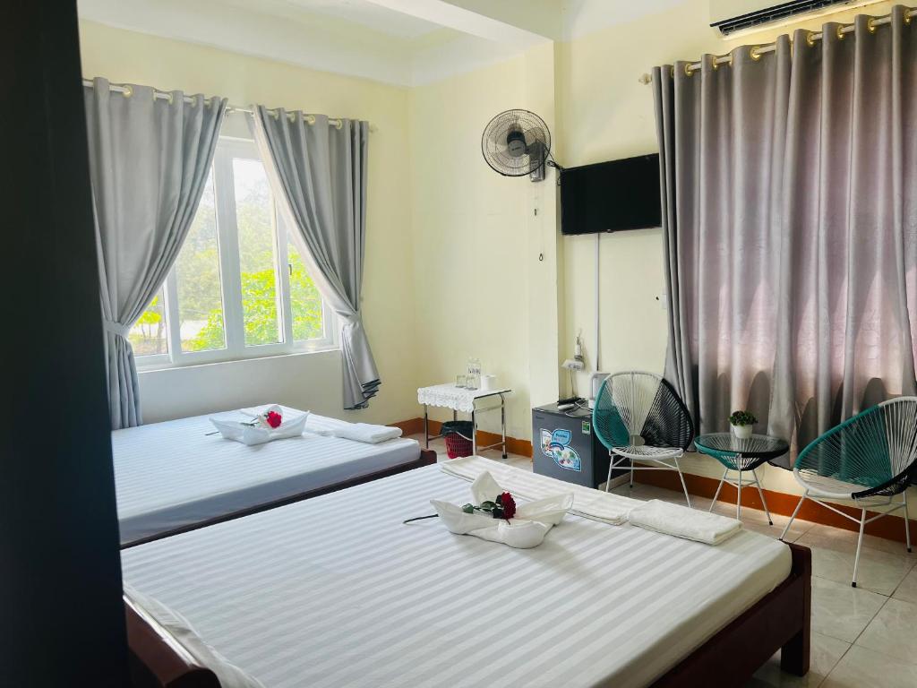 洞海View Nhat Le Beach Hotel的带2扇窗户的客房内的2张床