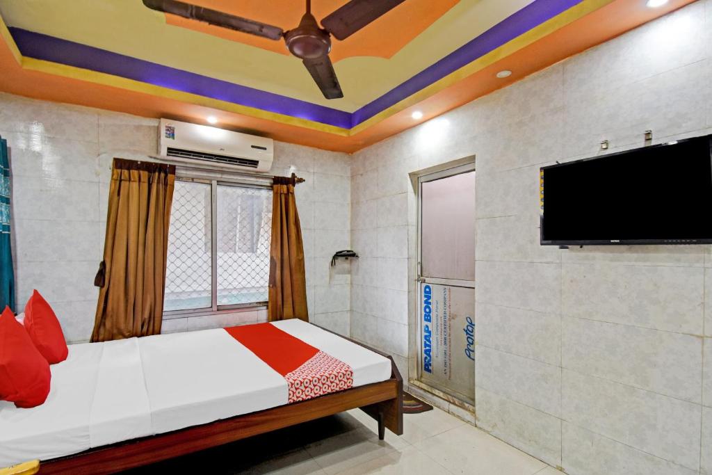 GauripurOYO Flagship The Rest的一间卧室配有一张床和一台平面电视
