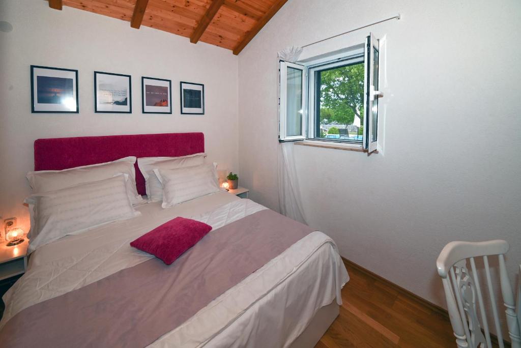 Duge NjiveVilla Silentio, complete privacy near Makarska的一间卧室配有一张大床和红色床头板