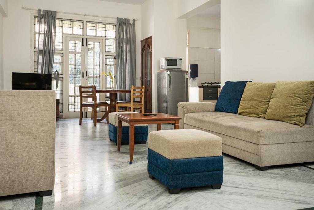 班加罗尔Aishwarya Mystic Apartotel的客厅配有沙发和桌子