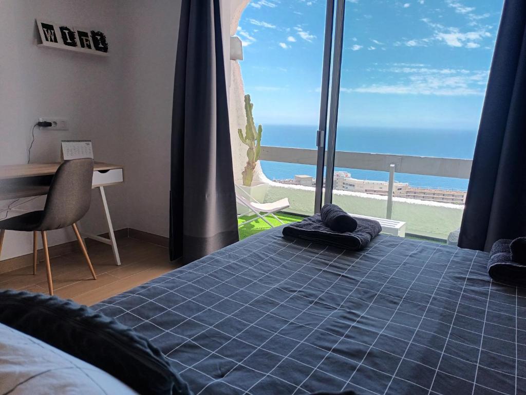 塔瓦伊瓦Modern open-plan studio with terrace and sea view的一间卧室设有一张床,享有海景