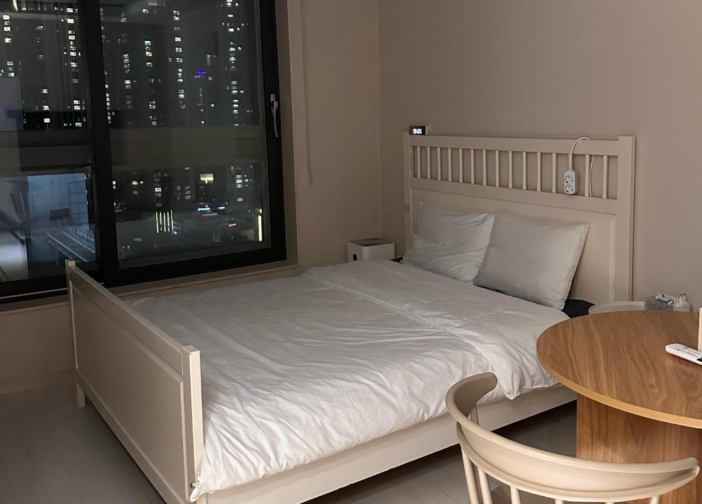 大邱Lilrose的一间卧室配有一张床、一张桌子和一个窗户。