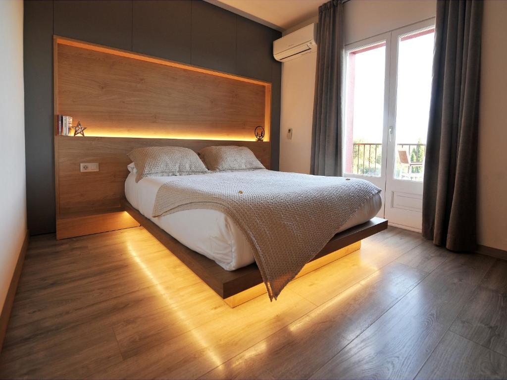 坎塔卢普斯Hostal Rural Can Pau的一间卧室配有一张大床和木制床头板