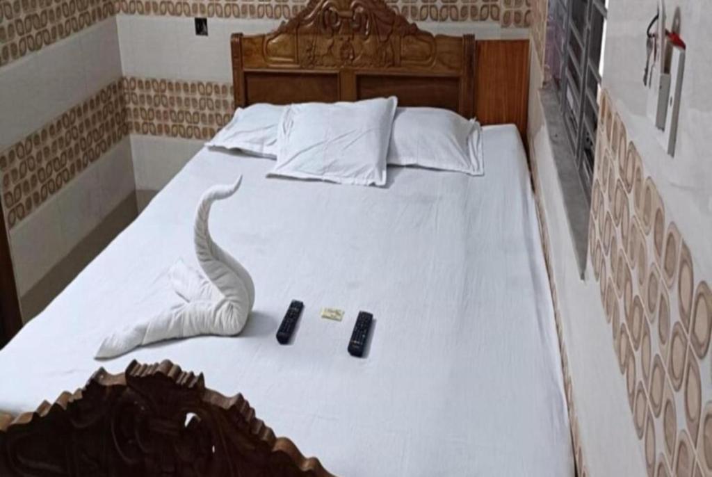 迪卡Hotel Chemistrica Digha Near Old Digha Sea Beach - Couple Friendly的一间卧室配有一张带两个遥控器的床