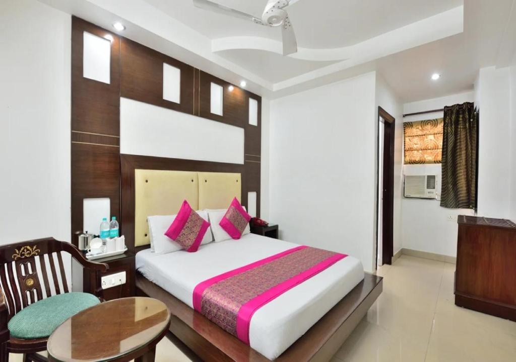 新德里Hotel University Stay @ A1Rooms的一间卧室配有一张床、一张桌子和一张桌子