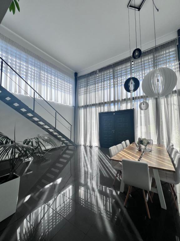 阿纳维索斯Luxe Two Bedroom Villa by Olivujoj的一间带木桌和椅子的用餐室