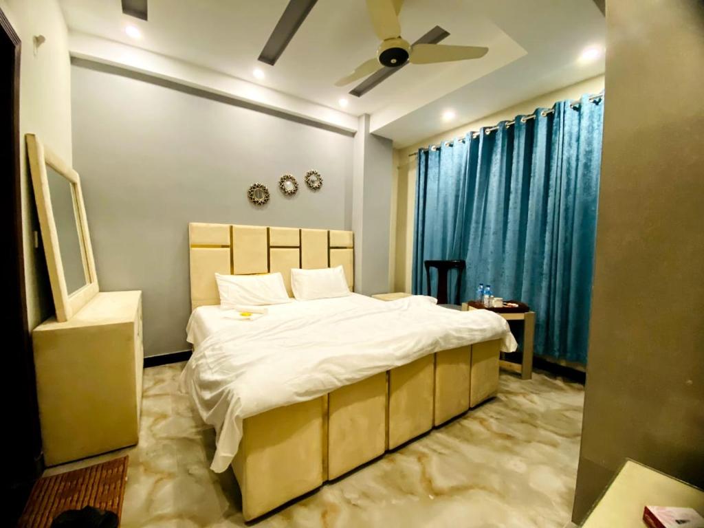 拉瓦尔品第Elite Living Hotels的一间卧室配有一张大床和吊扇