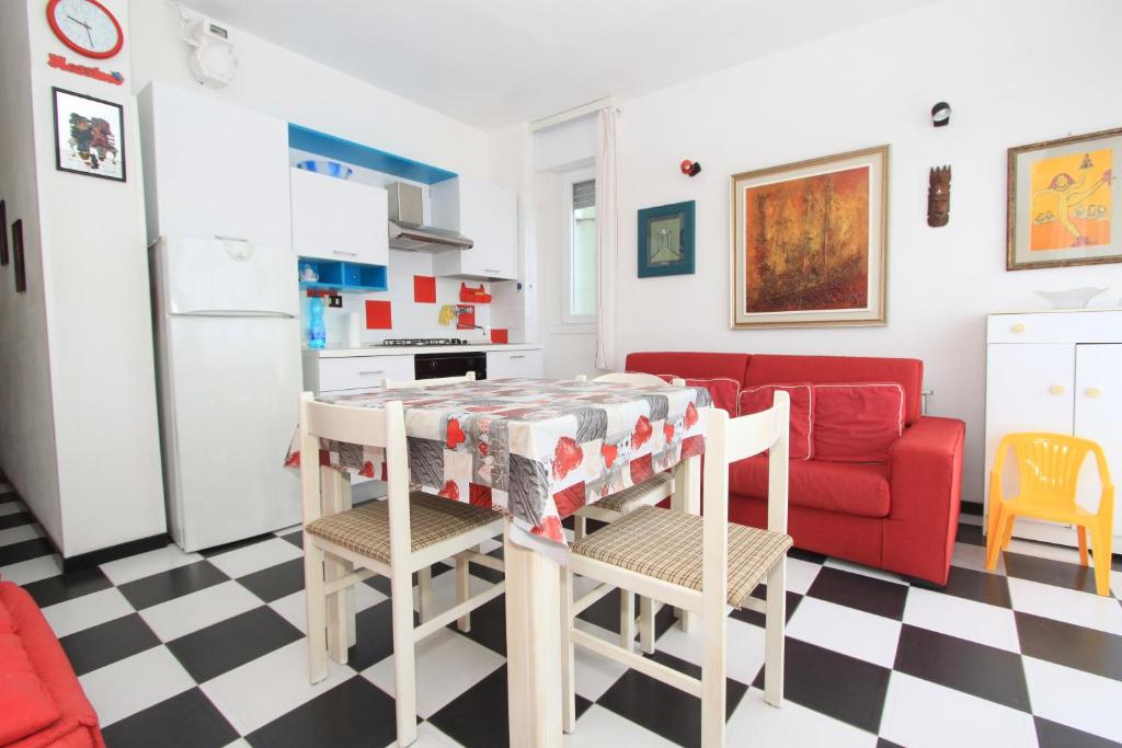 利多波波萨Eco del Mare Apartments的一间厨房和一间带红色沙发的客厅