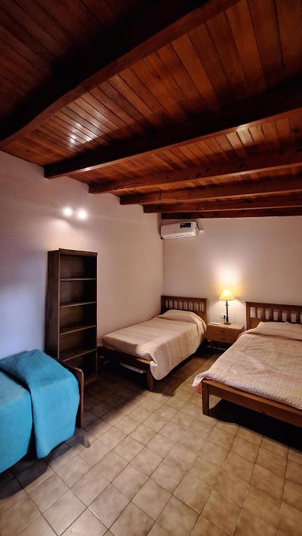 奇莱西托Casa Kuntur的一间卧室设有两张床和木制天花板