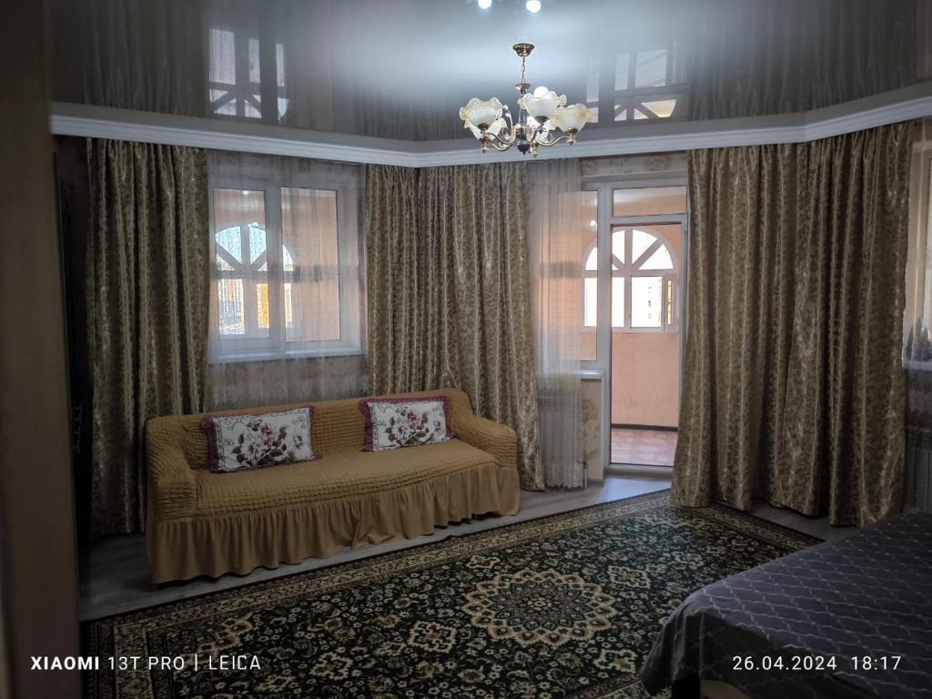 阿斯塔纳Уютная квартира комфорт класса112的带沙发和窗户的客厅