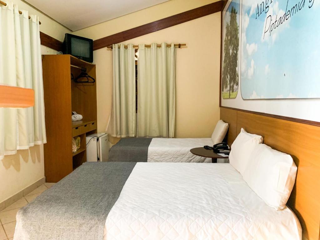 Capim BrancoHotel Fazenda Tucano的一间酒店客房,设有两张床和电视