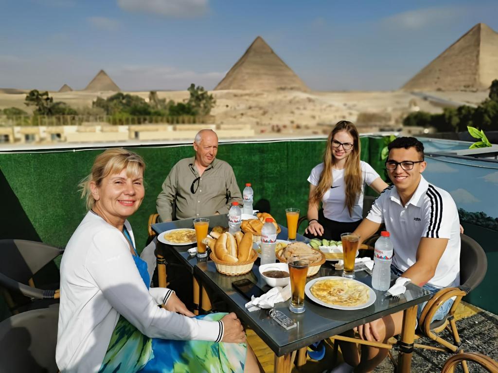 开罗Capital Of Pyramids Hotel的一群人坐在餐桌旁吃着食物