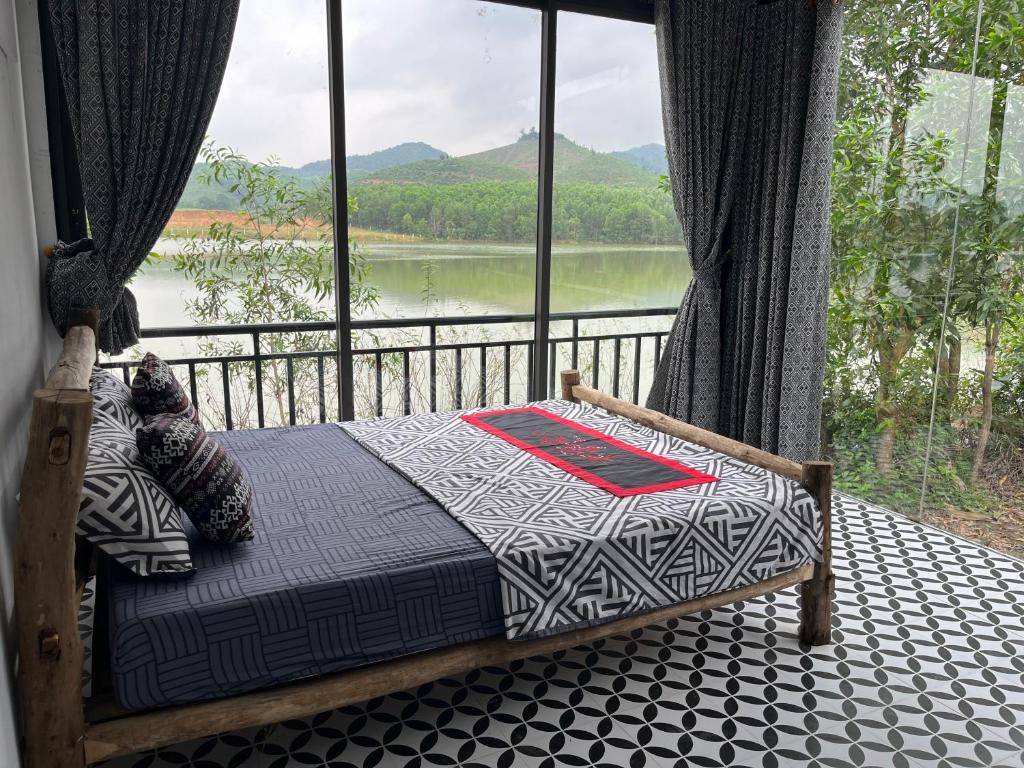 峰牙Nguyen Shack - Phong Nha Resort的一间卧室配有一张床,享有湖景