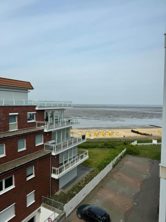 库克斯港Traumhafte Ferienwohnung - direkter Meerblick - 50m zum Strand in Cuxhaven Duhnen in 1A Lage im Haus Seehütte的从大楼的阳台上可欣赏到海滩景色