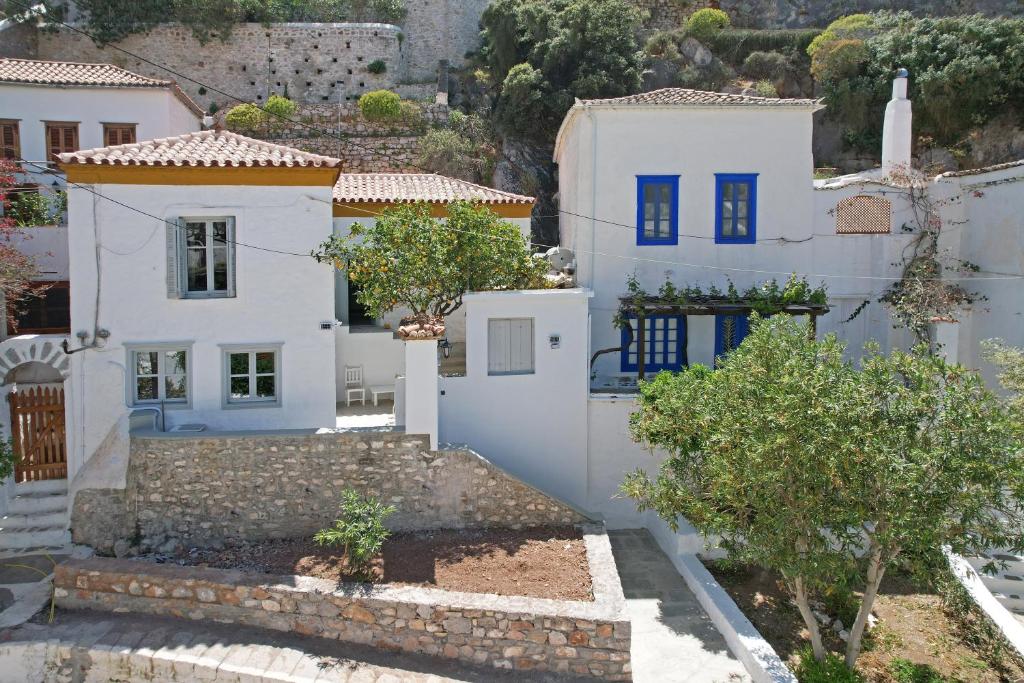 伊兹拉Douskos Citrus Apartments的白色墙壁和蓝色门的房子