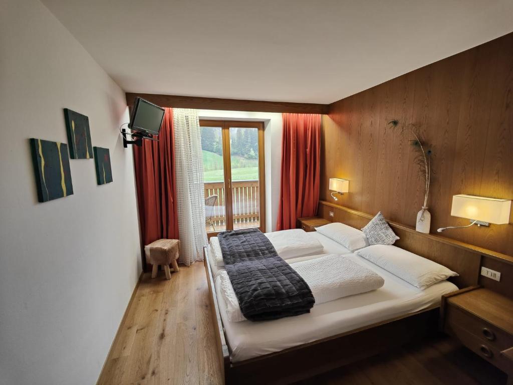 萨伦蒂诺Hotel Alpenblick的一间带床的卧室,位于带窗户的房间内