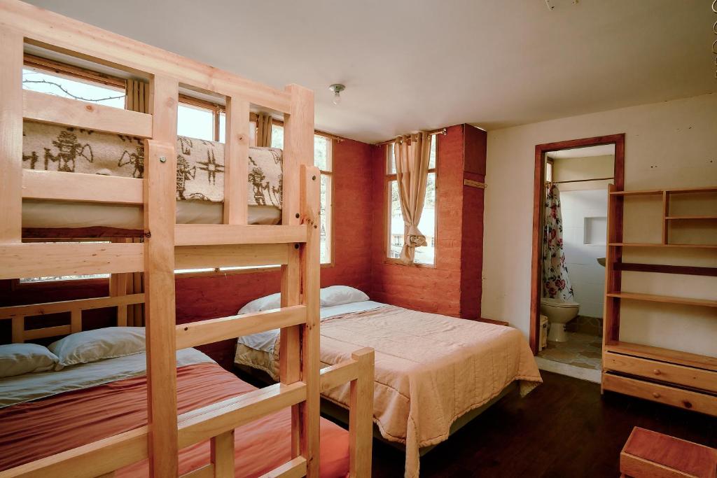 巴尼奥斯Backpackers-balcones-river-lodge的一间带两张双层床的卧室和一间浴室